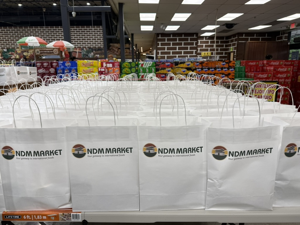Rows of Nam Dae Mun Market shopping bags arranged on a table inside the store