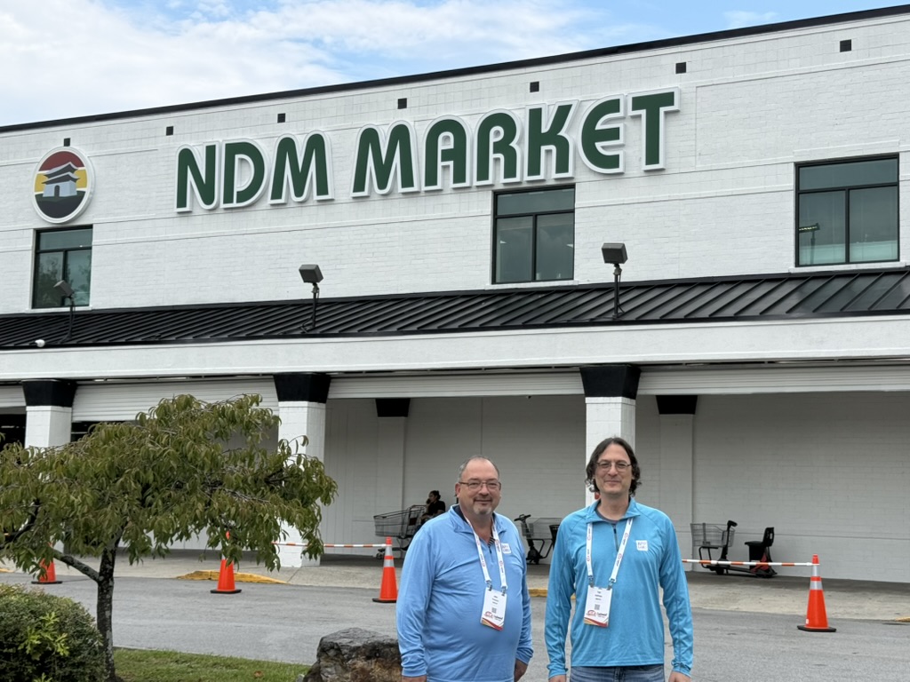 Two IGA event attendees standing outside the Nam Dae Mun Market storefront entrance